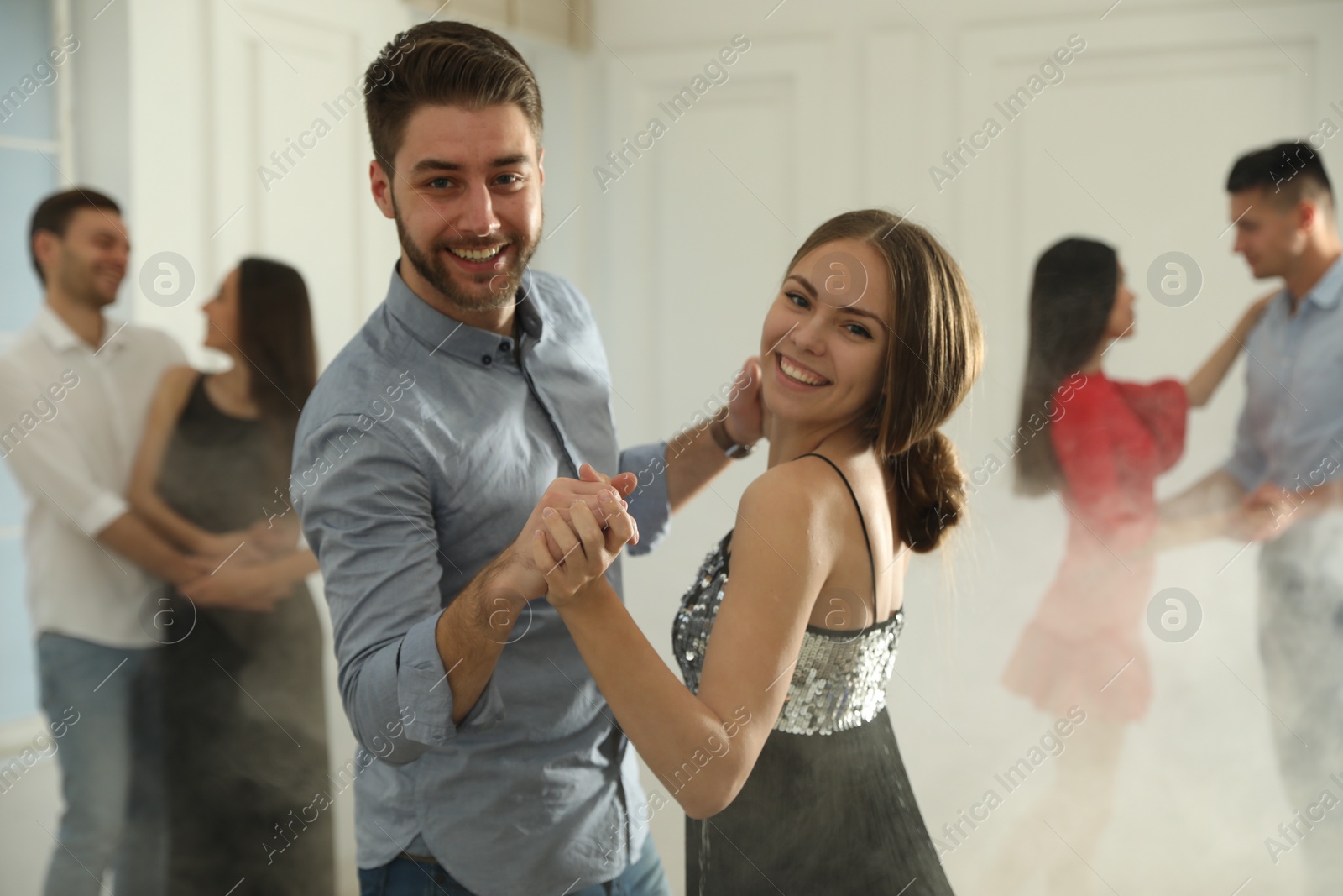 Photo of Lovely young couple dancing together at party