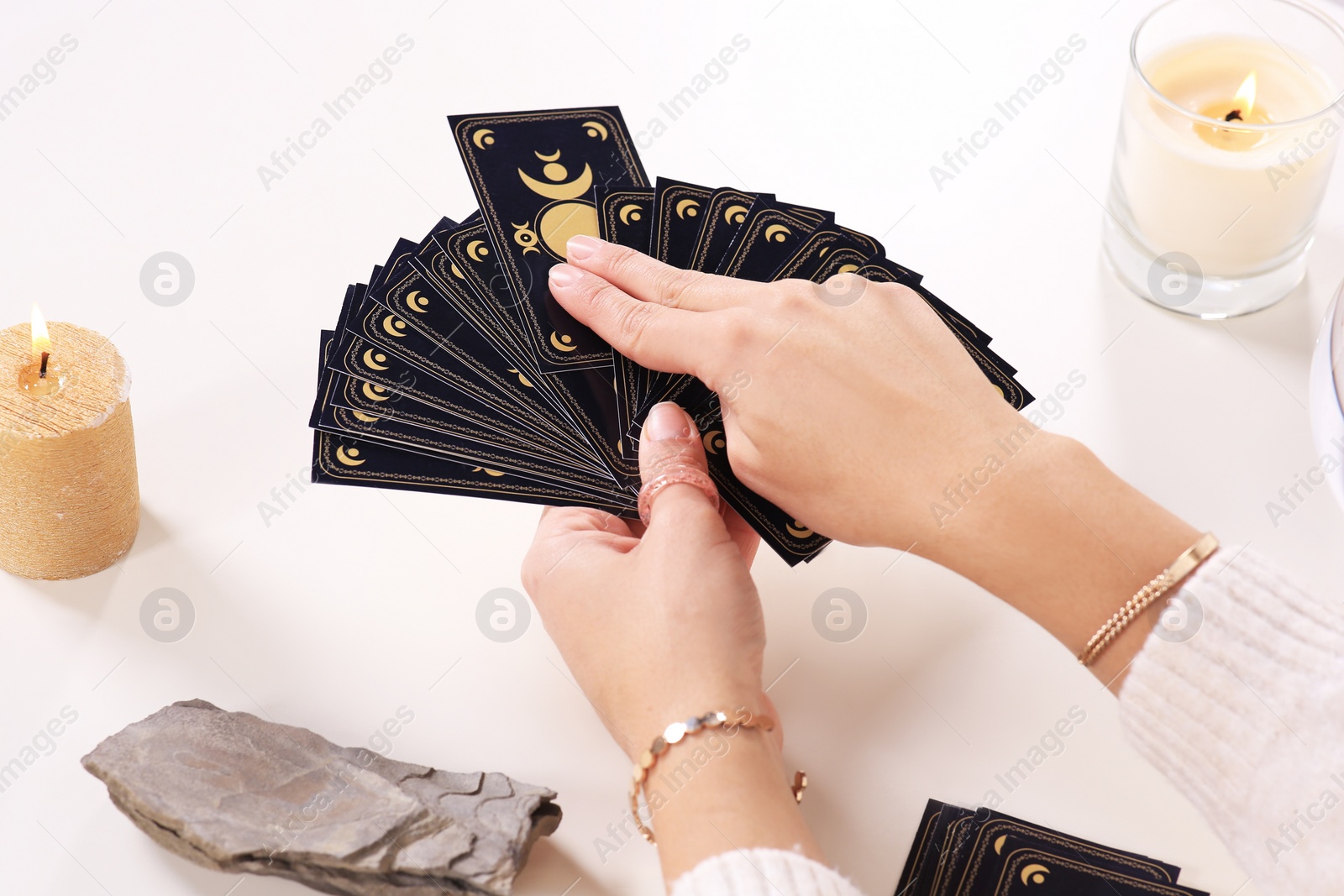 Photo of Soothsayer predicting future with tarot cards at table, closeup