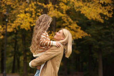 Photo of Happy mother spending time together with her daughter in autumn park