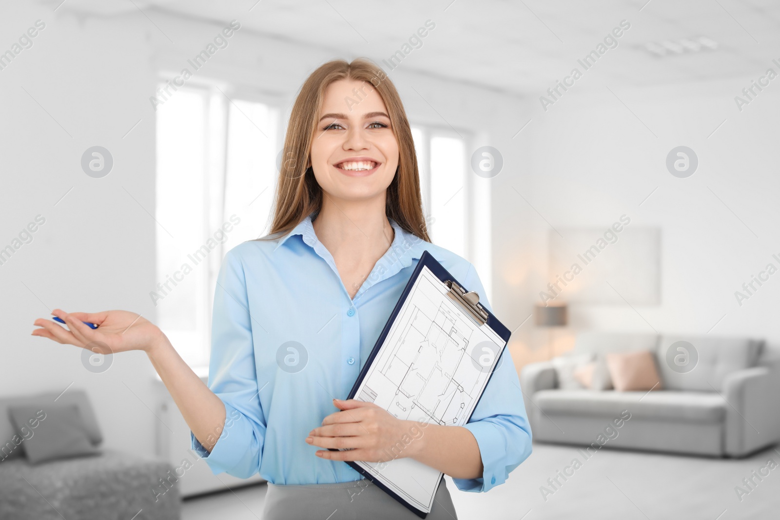 Photo of Beautiful real estate agent with clipboard indoors