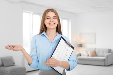 Photo of Beautiful real estate agent with clipboard indoors