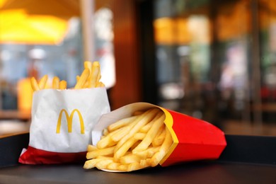 Photo of MYKOLAIV, UKRAINE - AUGUST 11, 2021: Big and small portions of McDonald's French fries on tray in cafe