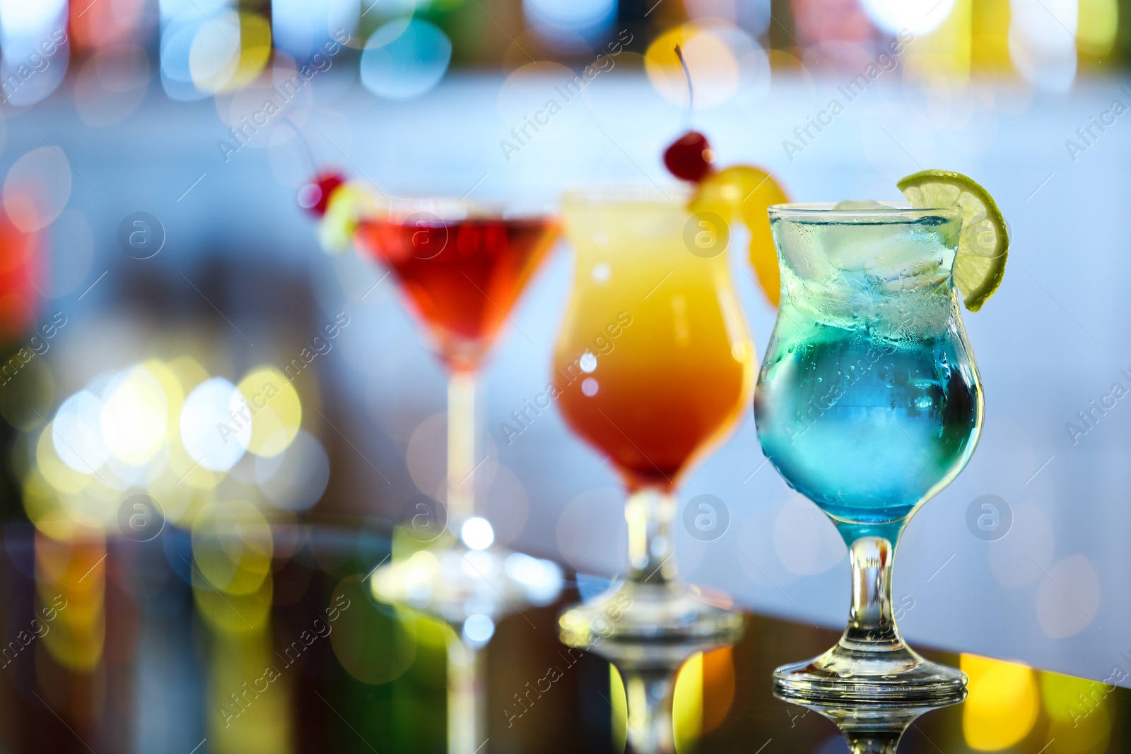 Photo of Glasses of fresh alcoholic cocktails on bar counter