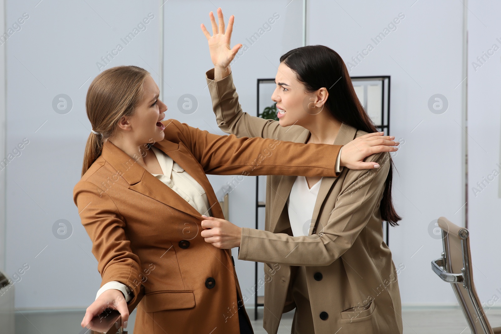 Photo of Emotional colleagues fighting in office. Workplace conflict