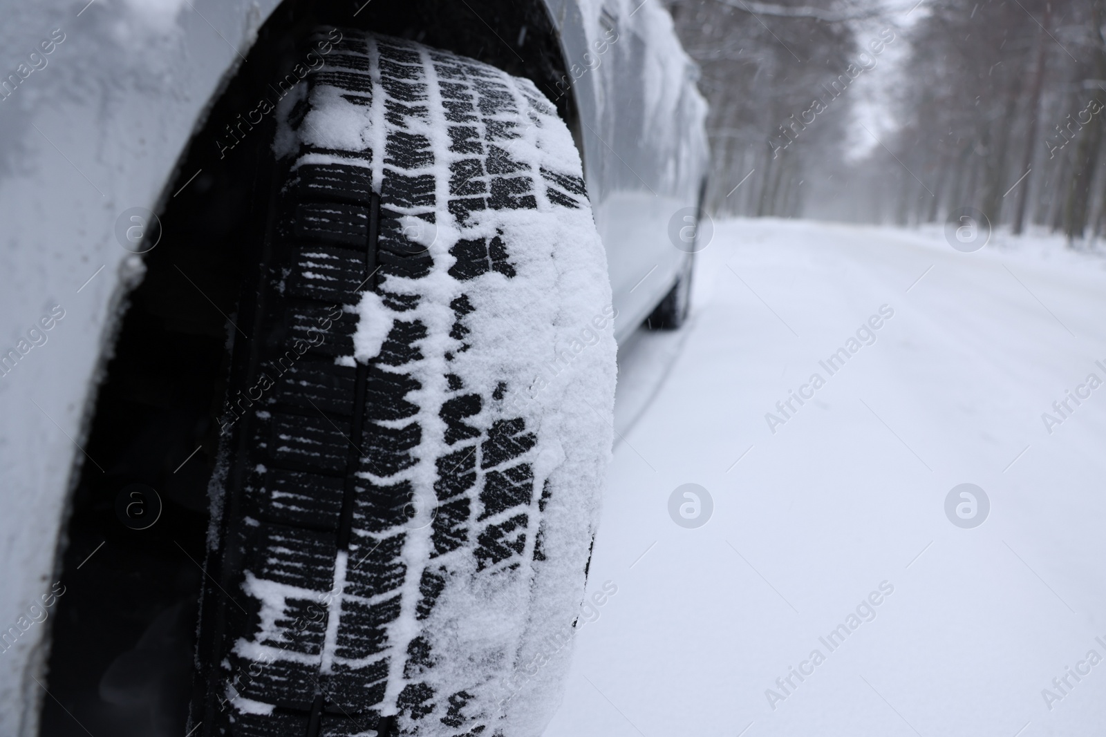 Photo of Car with winter tires on snowy road outdoors, closeup. Space for text