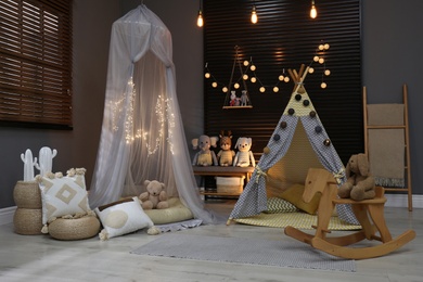Photo of Cozy kids room interior with play tents and toys