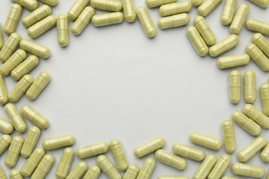 Photo of Frame of vitamin capsules on light grey background, top view and space for text. Health supplement