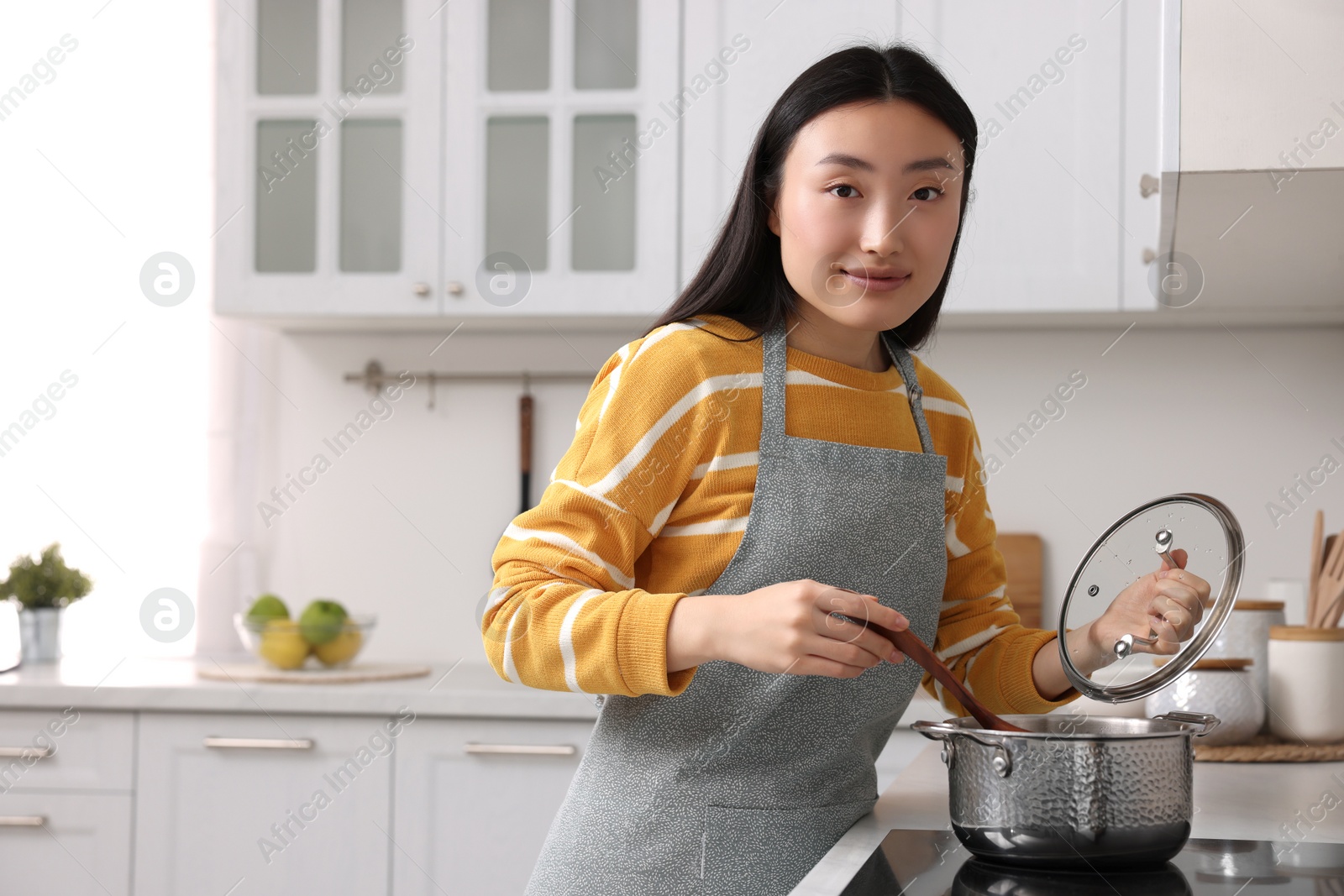 Photo of Beautiful woman cooking in kitchen. Space for text