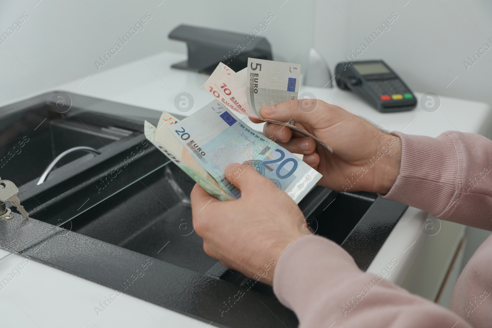 Photo of Man with money at cash department window, closeup. Currency exchange