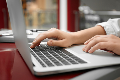 Blogger working with laptop in cafe, closeup