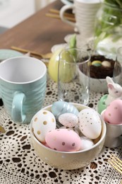 Photo of Festive table setting with painted eggs, closeup. Easter celebration