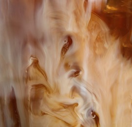 Photo of Glass with cold coffee and milk, closeup