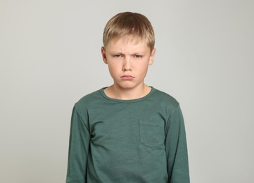 Upset boy on light grey background. Children's bullying