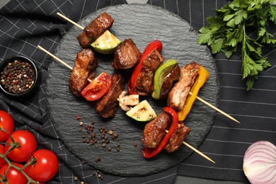 Photo of Delicious shish kebabs with vegetables and spices on table, flat lay