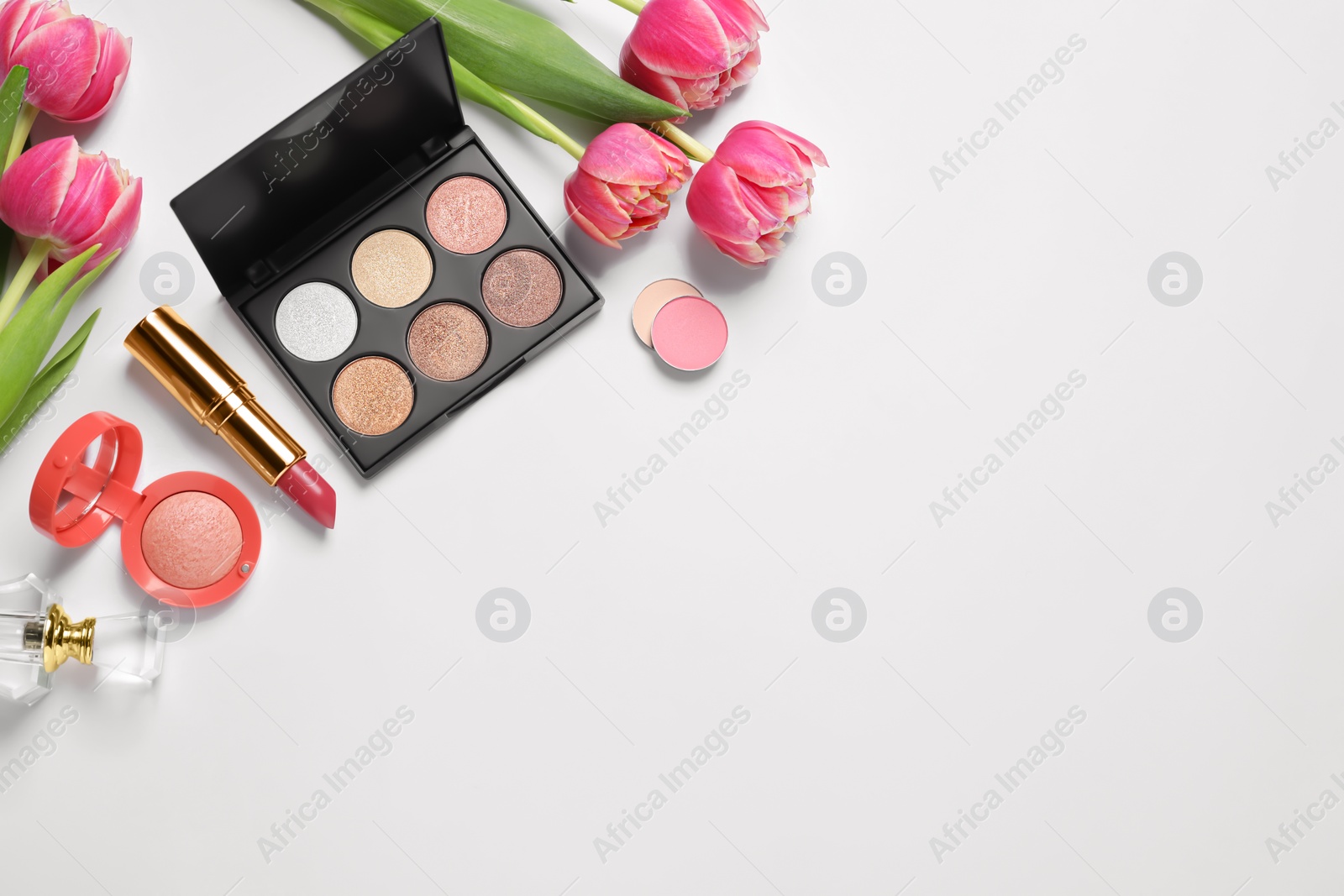 Photo of Flat lay composition with eyeshadow palette and beautiful flowers on white background, space for text