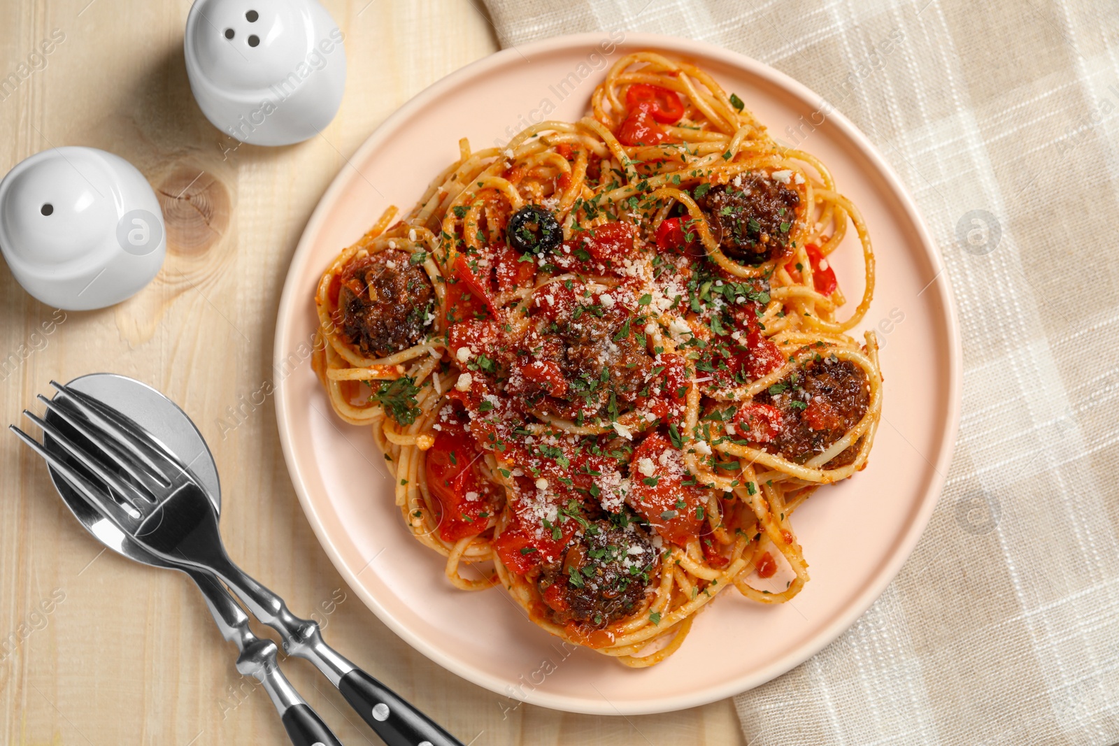 Photo of Delicious pasta with meatballs and tomato sauce served on wooden table, flat lay