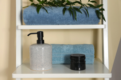 Photo of Shelving unit with toiletries near light wall indoors. Bathroom interior element