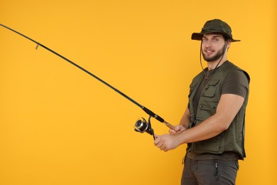 Photo of Fisherman with fishing rod on yellow background