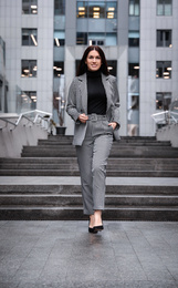 Photo of Full length portrait of beautiful woman in stylish suit on city street