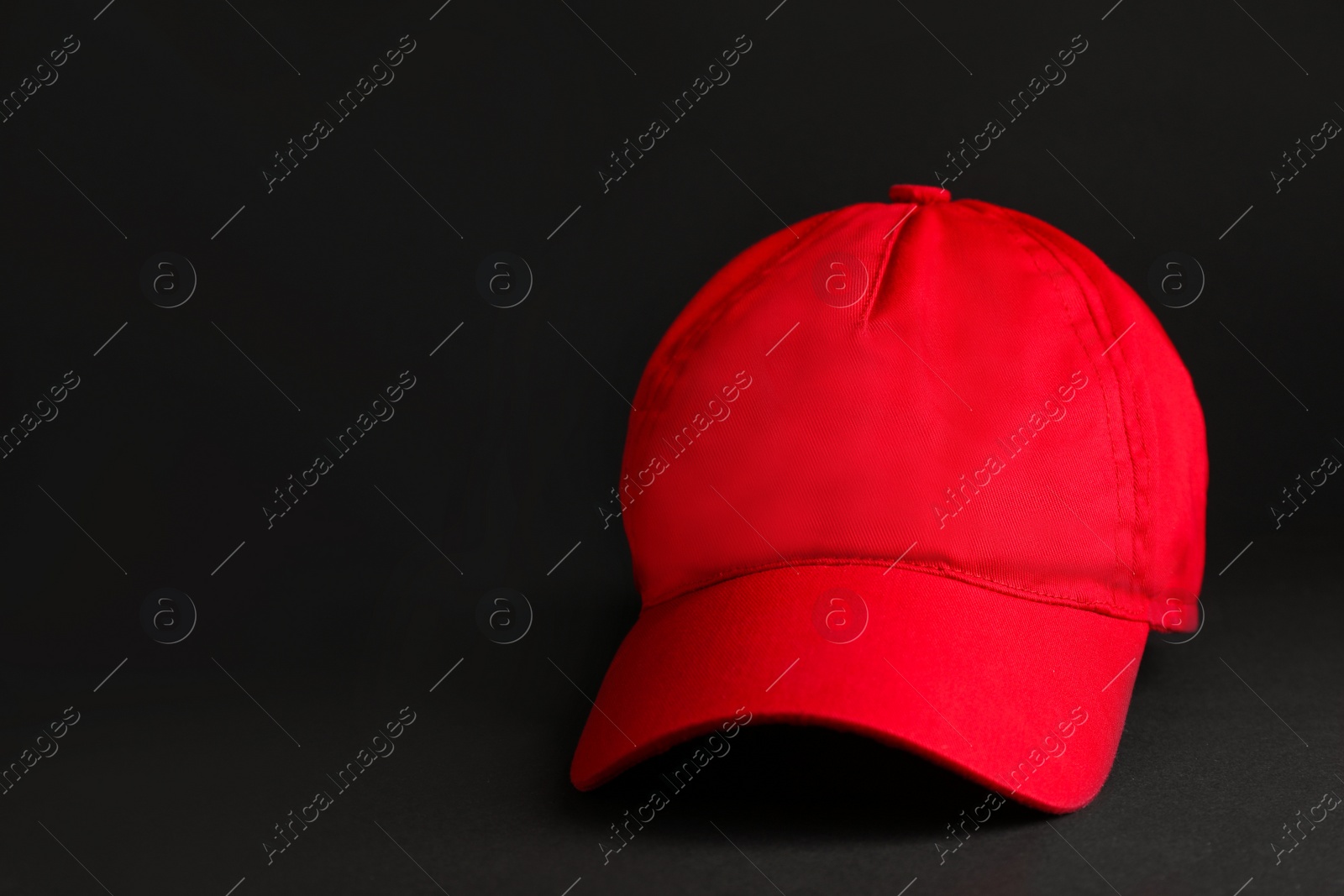 Photo of Baseball cap on black background, space for text