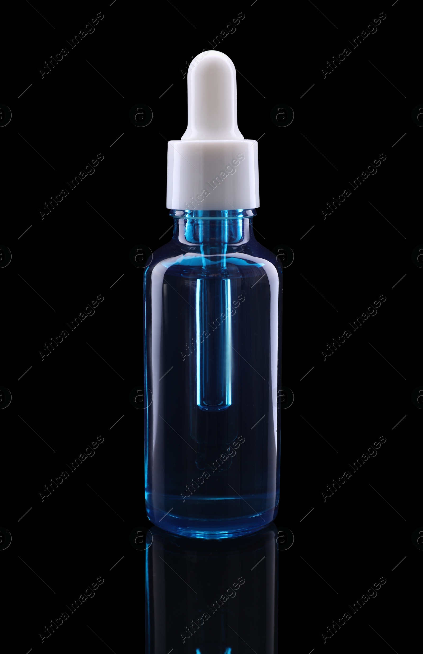 Photo of One blue bottle with tincture on mirror surface against black background