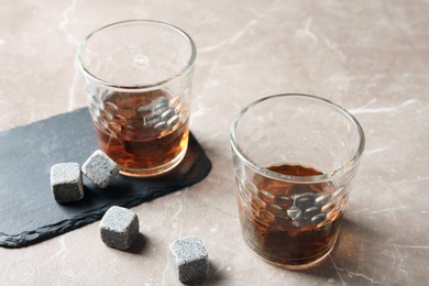 Glasses with liquor and whiskey stones on table