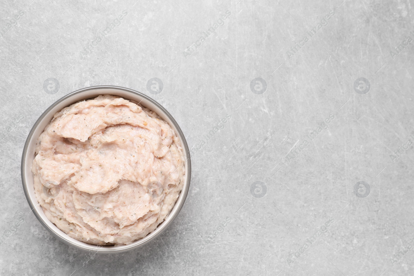 Photo of Delicious lard spread in bowl on light table, top view. Space for text