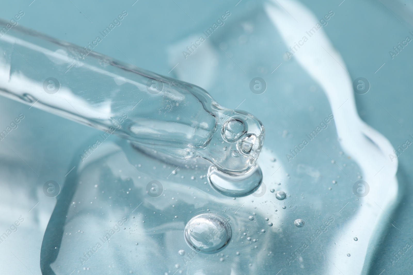 Photo of Pipette and cosmetic serum on light blue background, closeup