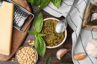 Photo of Tasty pesto sauce and ingredients on wooden table, flat lay