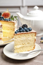 Photo of Piece of delicious homemade cake with fresh berries served on table