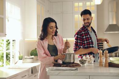 Photo of Lovely young couple cooking together in kitchen