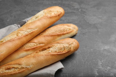 Photo of Tasty baguettes on grey table, closeup. Space for text