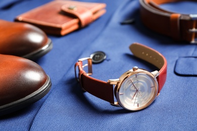 Luxury wrist watch and shoes on blue shirt, closeup