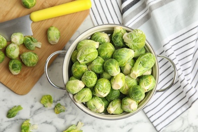 Photo of Fresh Brussels sprouts on white marble table, flat lay