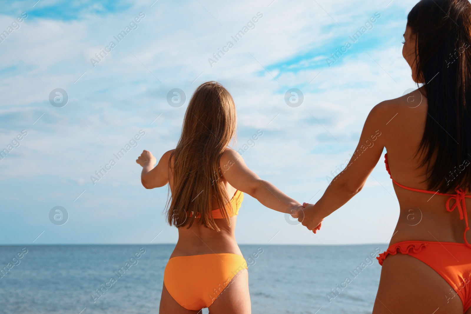 Photo of Young couple in bikini spending time together on beach