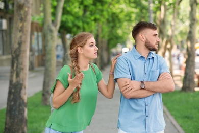 Photo of Young couple arguing on street. Problems in relationship