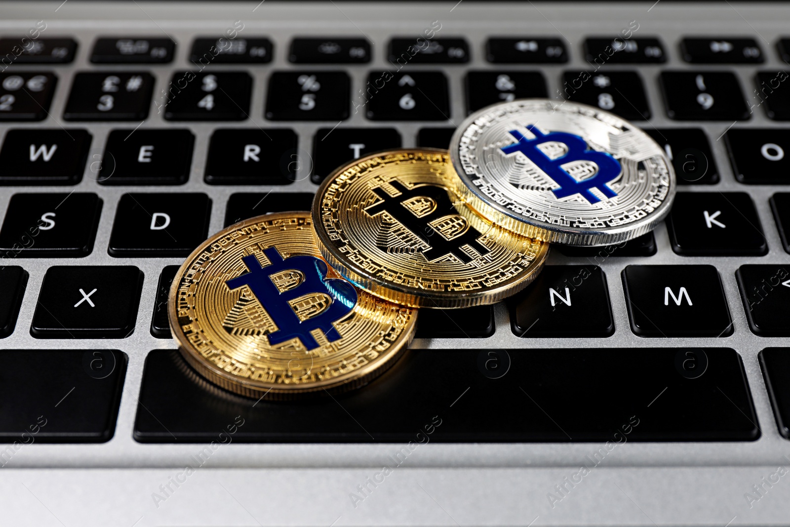 Photo of Golden and silver bitcoins on computer keyboard, closeup