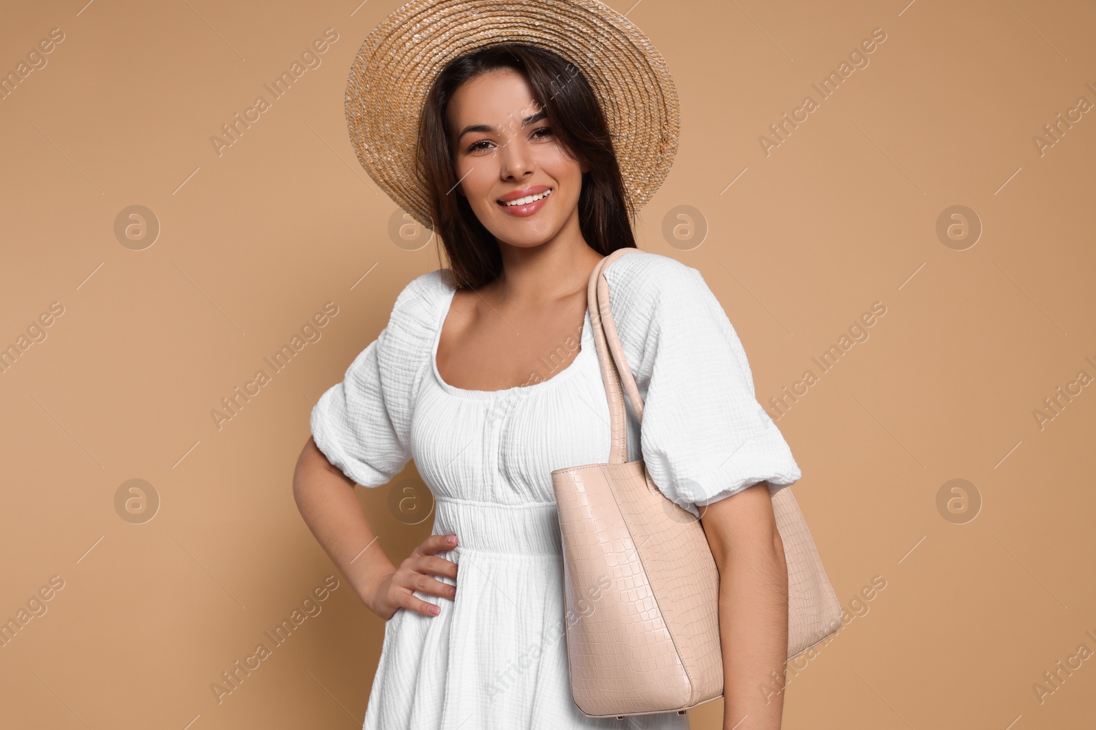 Photo of Young woman with stylish bag on beige background