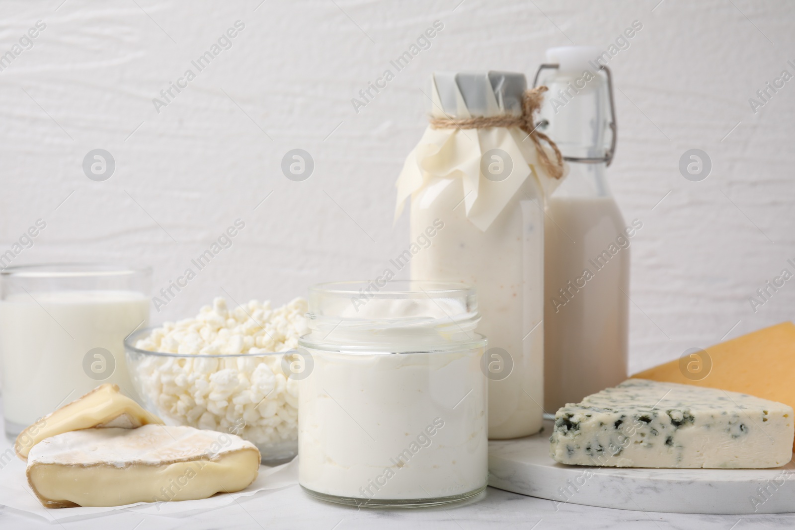 Photo of Different fresh dairy products on white marble table