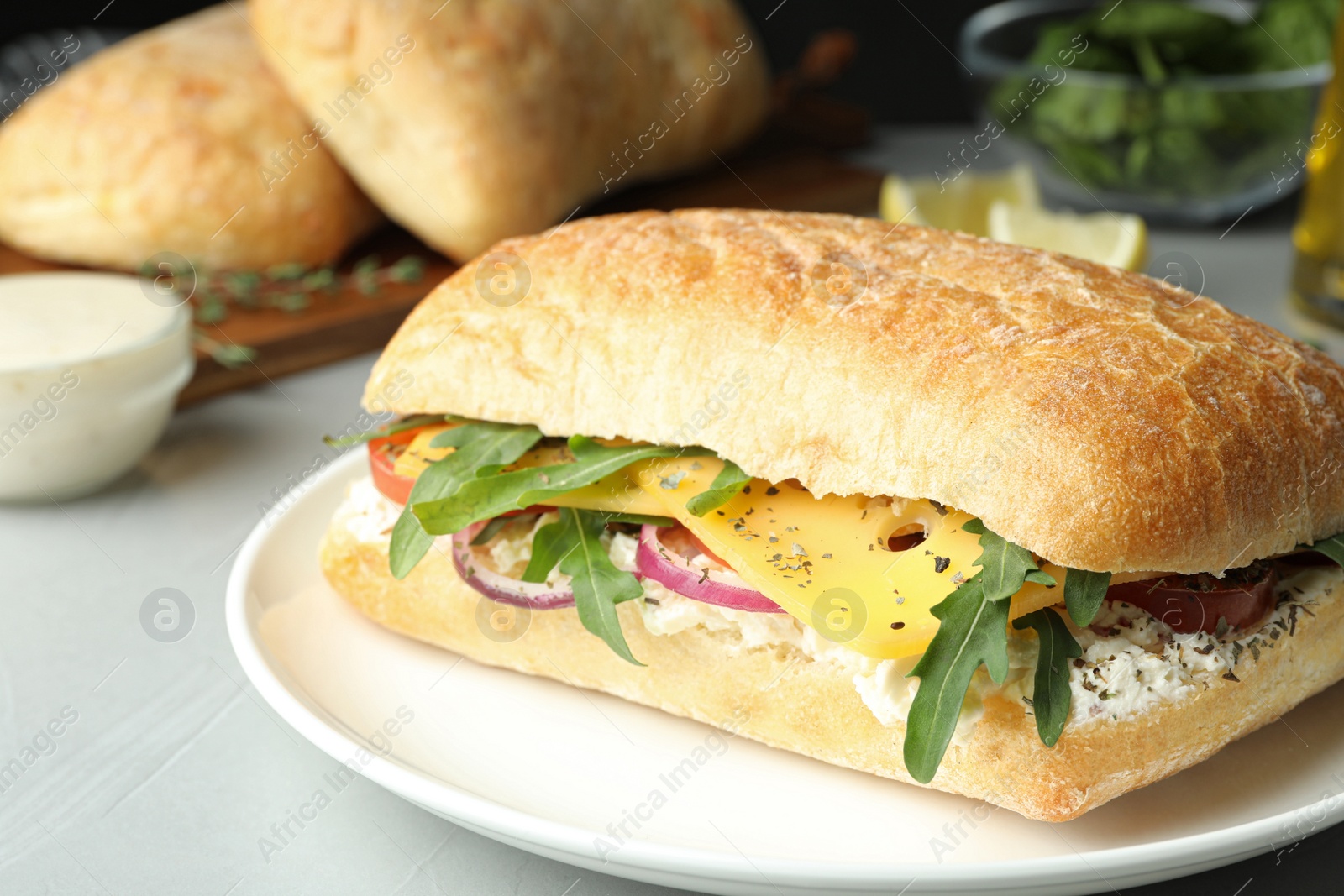 Photo of Delicious sandwich with fresh vegetables and cheese on light table