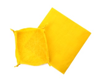 Photo of Yellow beeswax food wraps on white background, top view