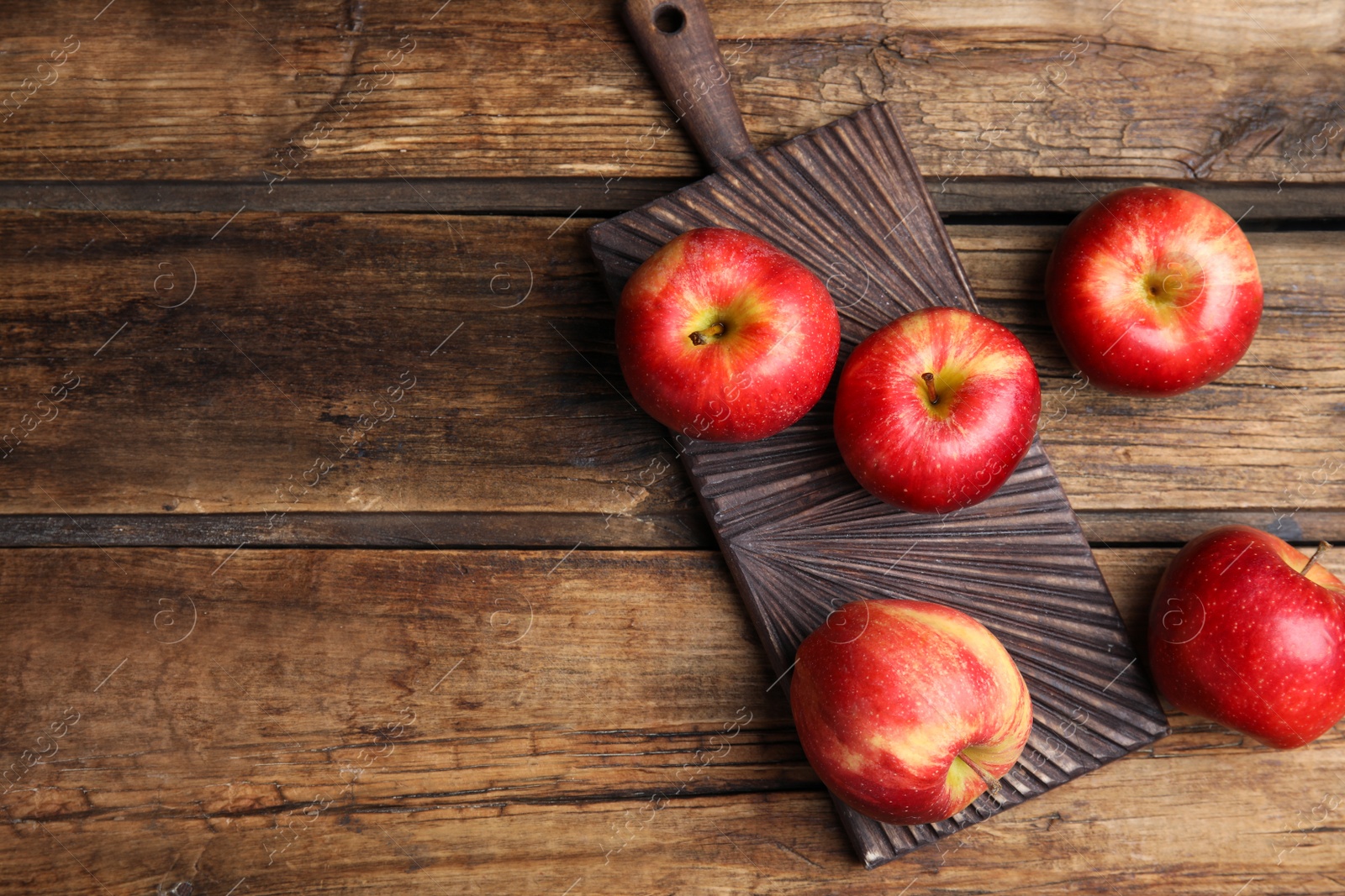 Photo of Fresh ripe red apples on wooden table, flat lay. Space for text