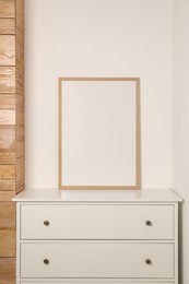 Blank frame on chest of drawers indoors. Space for design