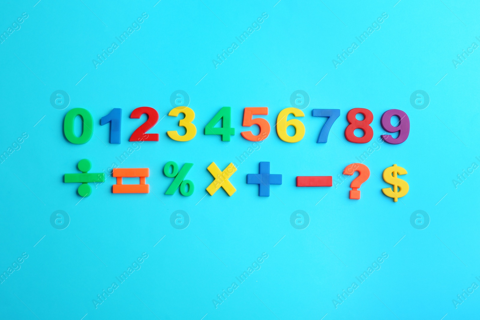 Photo of Colorful magnetic numbers and math symbols on light blue background, flat lay