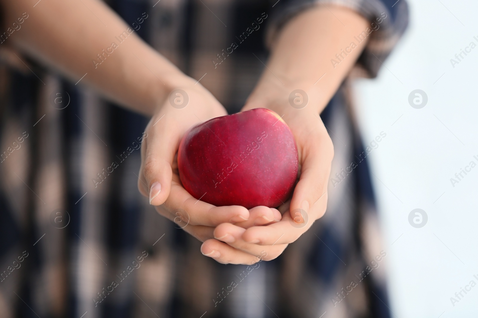 Photo of Woman holding ripe red apple, closeup