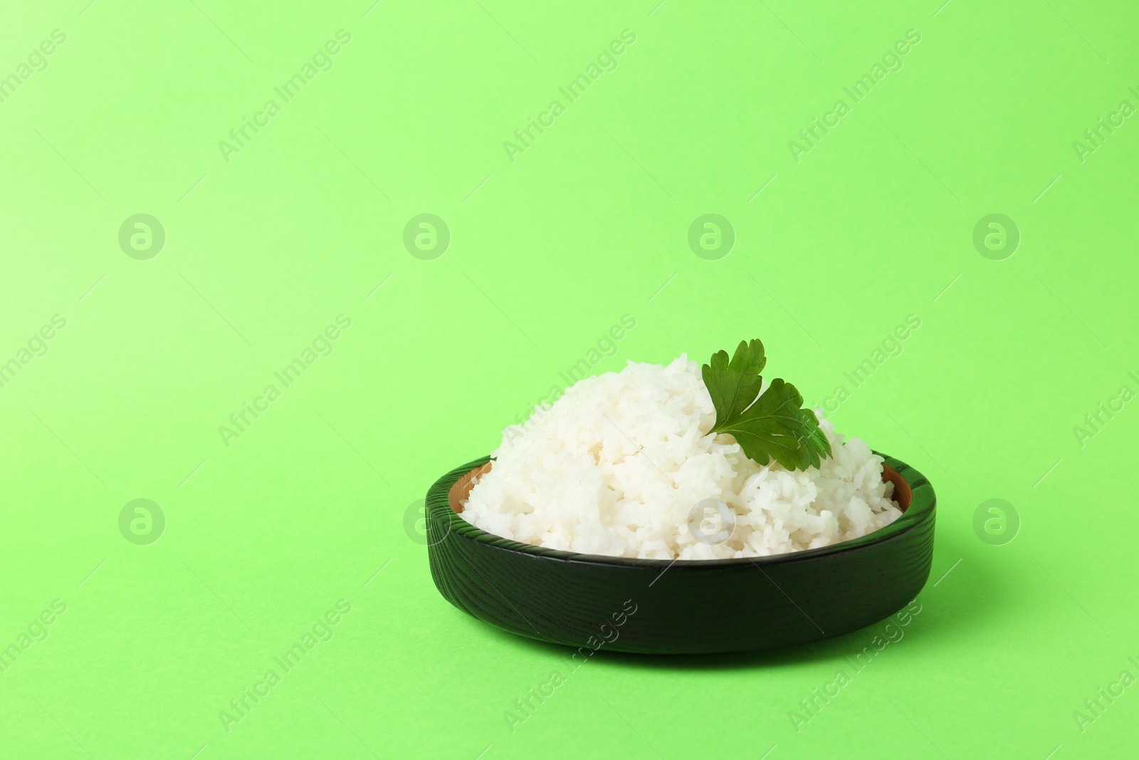 Photo of Bowl of boiled rice on color background. Space for text