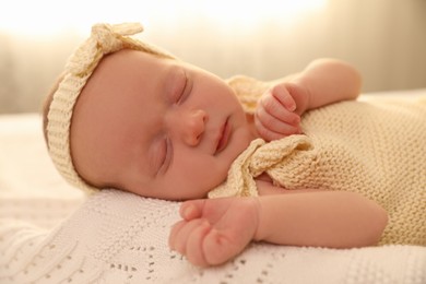 Photo of Adorable newborn baby sleeping on knitted plaid, closeup
