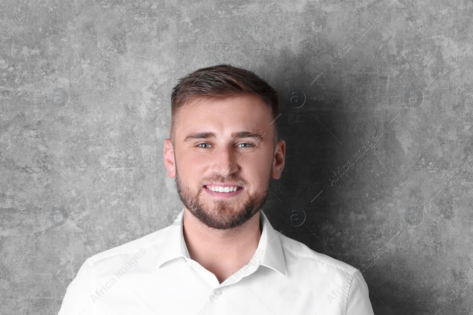 Photo of Portrait of handsome happy man on grey background