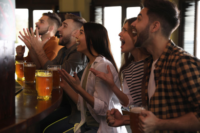 Group of friends watching football in sport bar