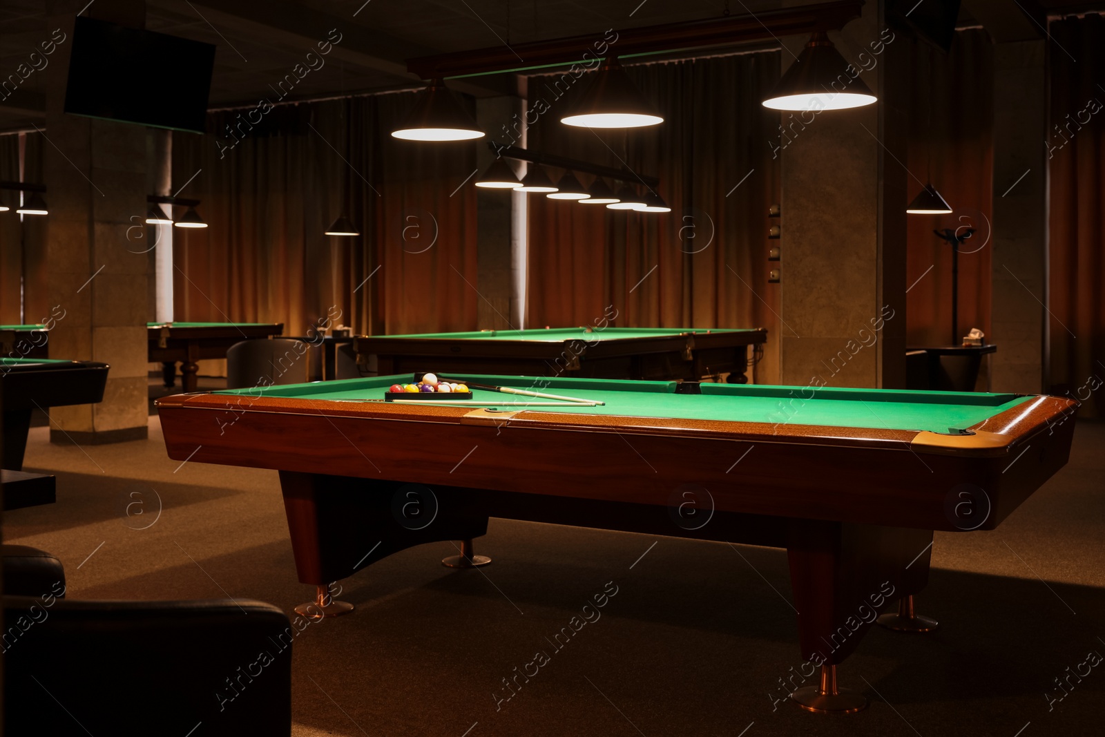 Photo of Billiard tables with balls and cues in club